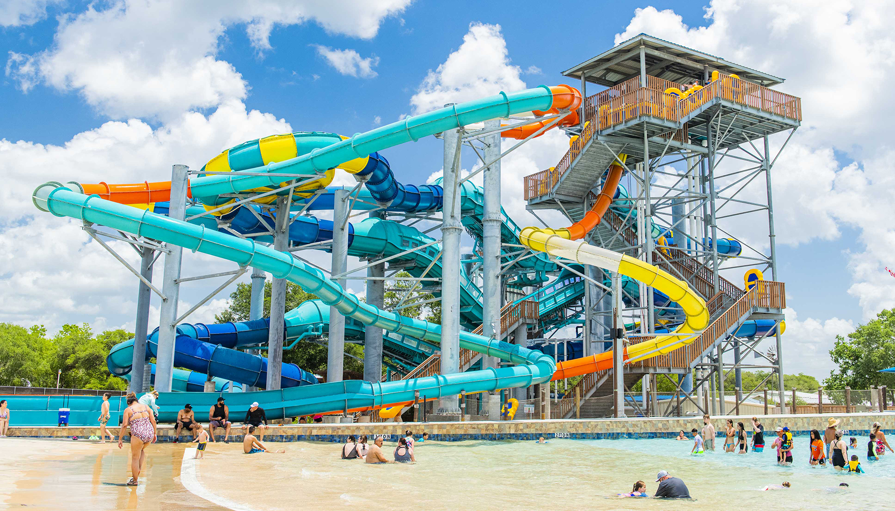 An overhead view of a brightly colored water slide complex with intertwined colored tubes.